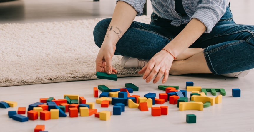 Picture of mom picking up legos after kids