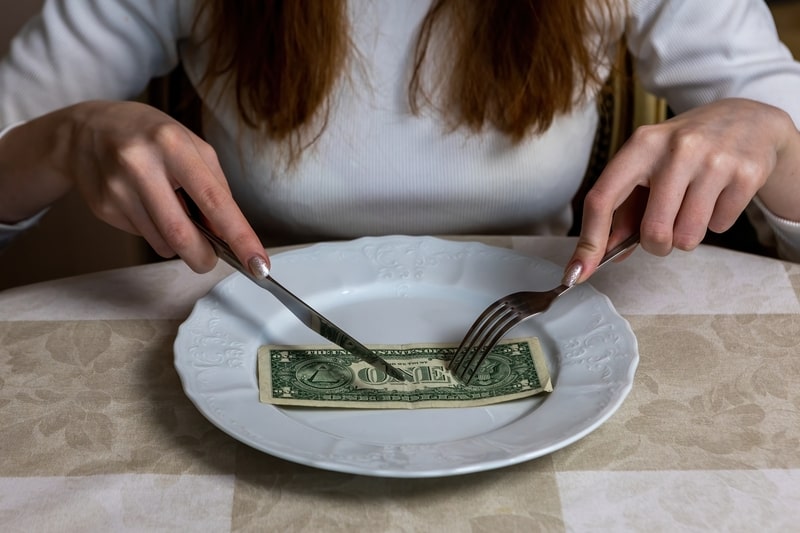 Picture showing a woman eating a dollar bill