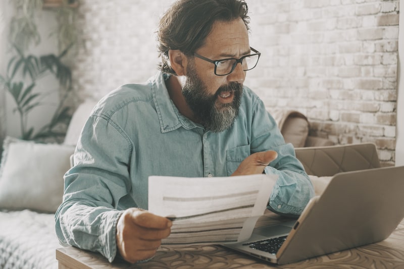 Picture of a man being upset with his bills