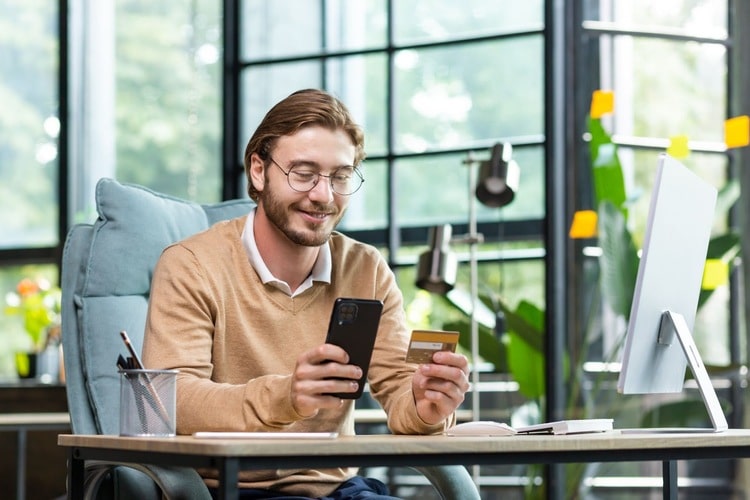 Photo showing a man making as purchase on his phone