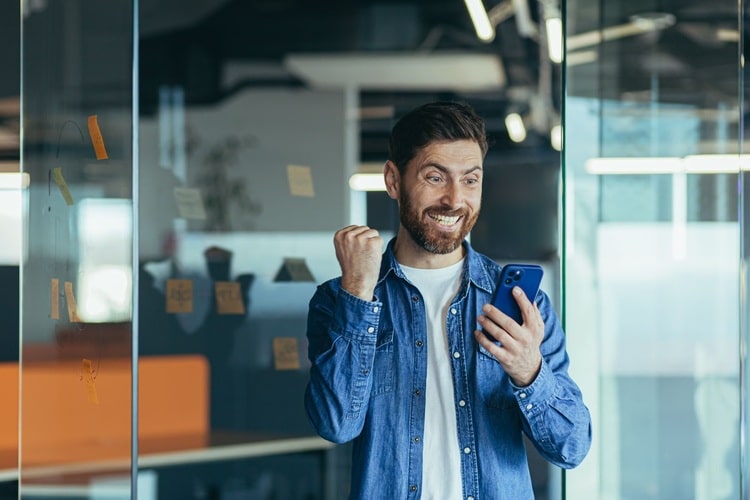 Photo showing a man looking happy at the screen