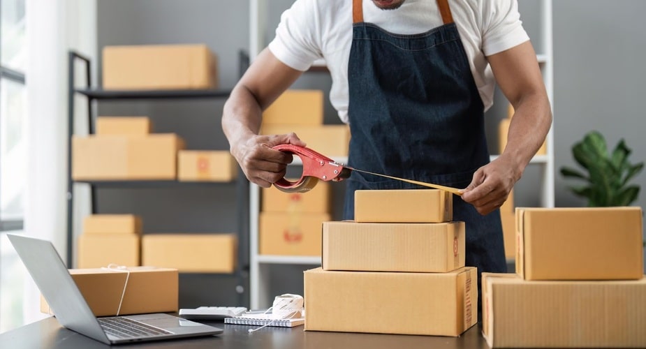 Picture of a man packing his products before shipping them off