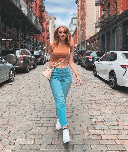 Photo of isabella walking down a street with cars aroundher