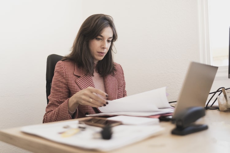 Picture of a woman doing paperwork with documents