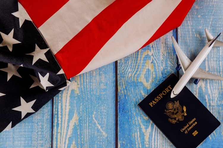 picture of an american flag, passport and an airplane