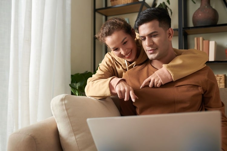 Picture of a man and a woman working on a laptop launching pre-built dropshipping stores