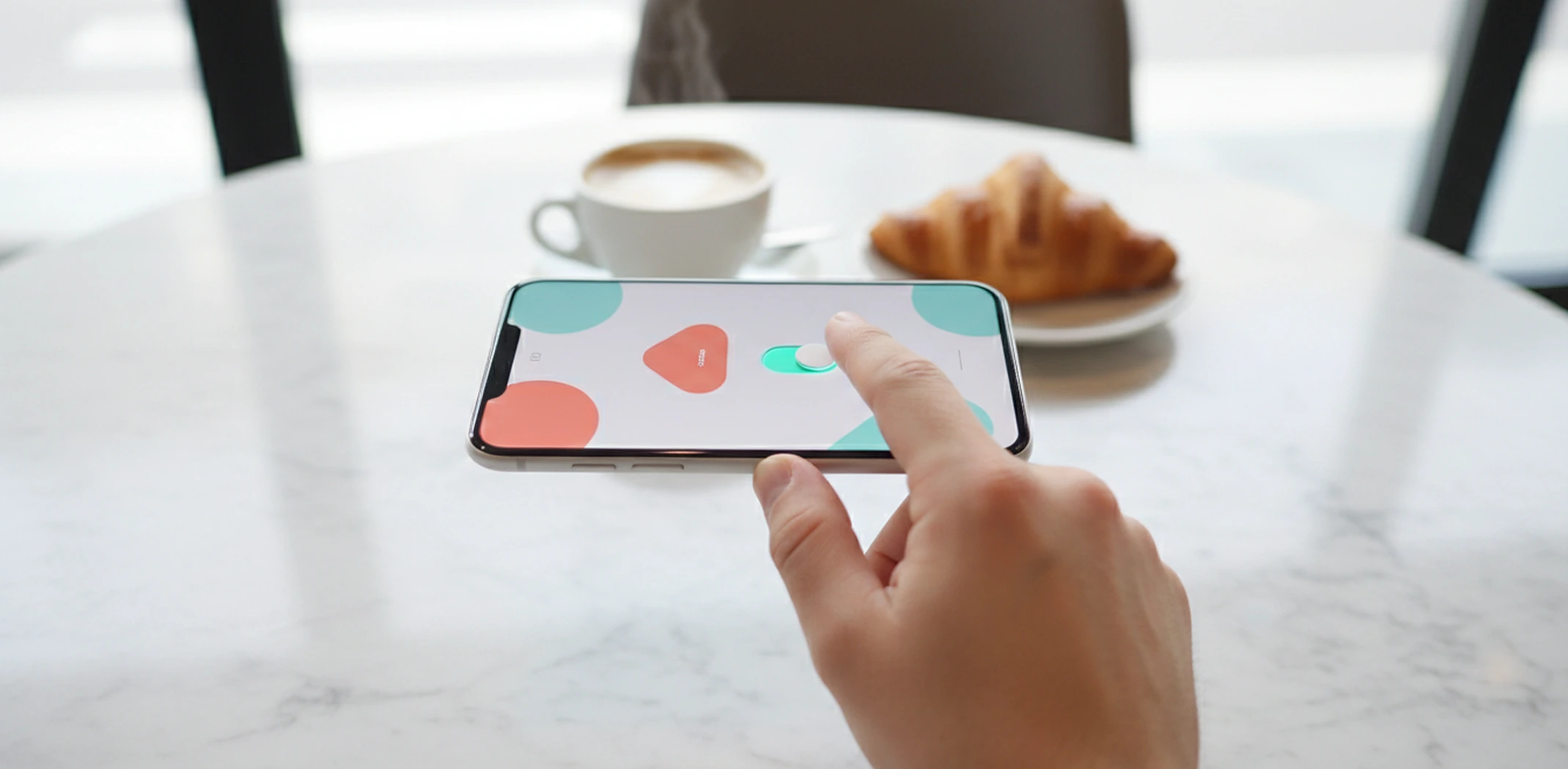 Hand switching on an ad campaign on a smartphone at a café table